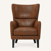 Front | distressed brown embossed faux-leather wingback chair centered on a cream studio ground, dark nailhead trim and black tapered legs
