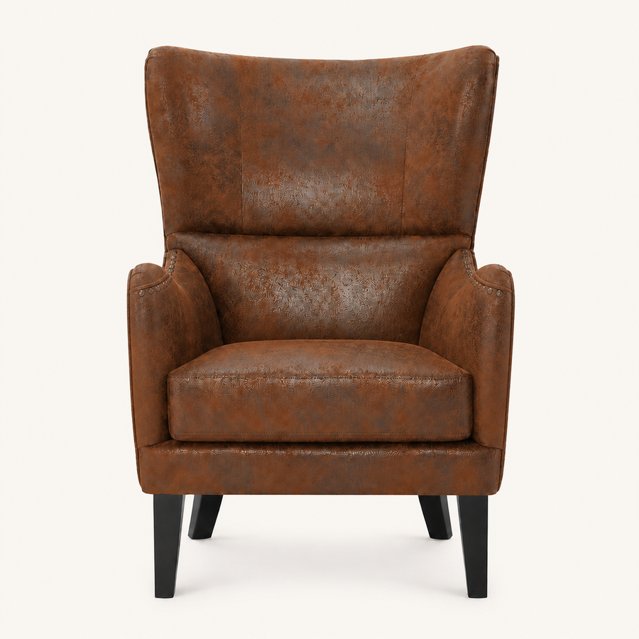 Front | distressed brown embossed faux-leather wingback chair centered on a cream studio ground, dark nailhead trim and black tapered legs