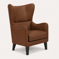 Three-quarter | studio view showing the raised embossed upholstery pattern, wing profile, dark nailhead trim and black tapered legs