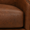 Close detail | raised embossed brown faux-leather pattern and stitching on the seat and arm