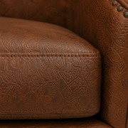 Close detail | raised embossed brown faux-leather pattern and stitching on the seat and arm