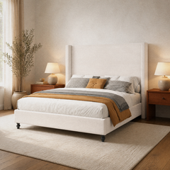Room 1 angle | Three-quarter bedroom view showing the tall wingback headboard, upholstered side rail, footboard, and dark feet