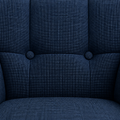 Tufting detail | close view of two dark upholstered buttons on the armchair's basketweave back