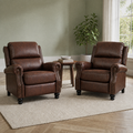 Room | two reddish-brown distressed faux-leather push-back recliners with rolled arms, brass-tone nailhead trim and black turned bun feet on a plain oatmeal rug in a sage room