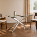 Angle | same ivory plaster dining room, table at a three-quarter so the glass top and silver pedestal both read