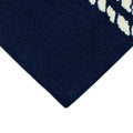 Corner | a corner of the rug showing the tufted navy field and finished edge