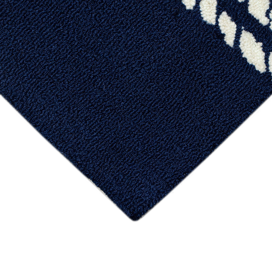 Corner | a corner of the rug showing the tufted navy field and finished edge