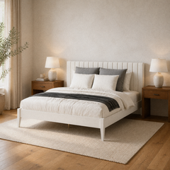 Room 1 angle | Pale channel-panel bed viewed from the foot corner with layered bedding