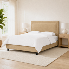 Room 2 angle | Corner view with a window, plant, nightstands, and a pale rug