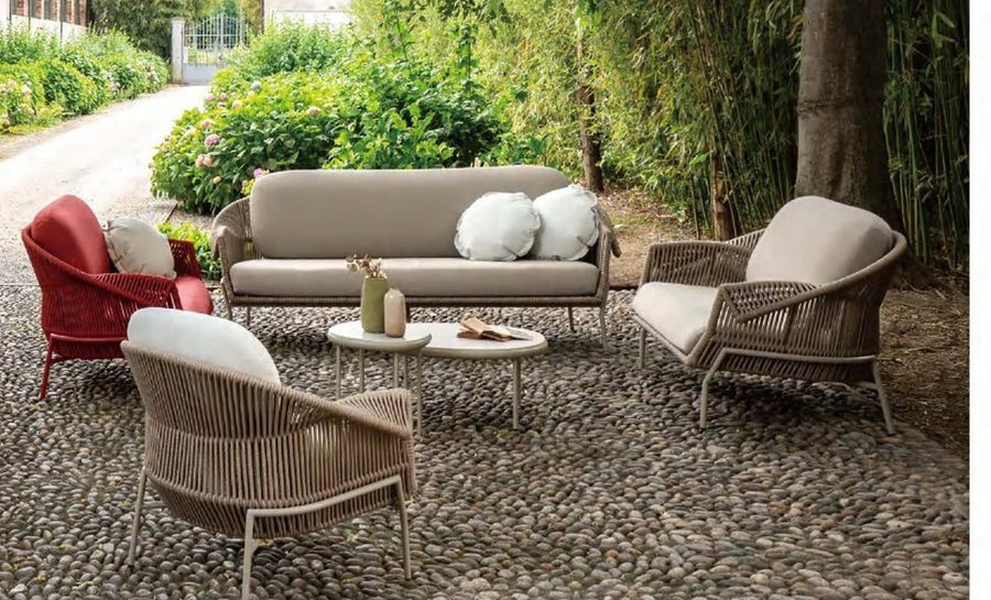 Rope weave outdoor lounge chairs and sofa in a gravel courtyard garden