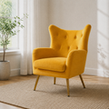 Room | second angle of the mustard velvet wingback chair on the plain oatmeal rug beside the left window