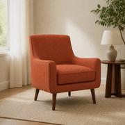 Reading room angle | Left three-quarter view of burnt-orange armchair with piped cushion and tapered wood legs