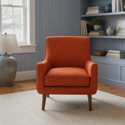 Blue-gray room | Burnt-orange armchair in a cool beadboard sitting room with a bookcase and plain rug
