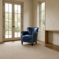 Scale | Navy armchair beside a full-height doorway in a pale entry room