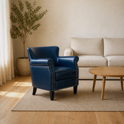 Room angle | Navy faux leather armchair from a left three-quarter view in a warm oak room