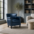 Blue-gray room | Navy faux leather armchair beside a black-framed window and bookcase