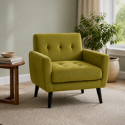 In a room | olive-green velvet armchair in a sage-green room with a right-side window, plain oatmeal rug, leafy plant and walnut side table