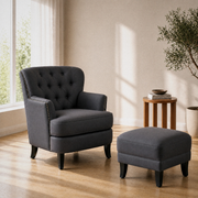 Wide three-quarter view of the complete dark gray armchair and ottoman set in a reading room