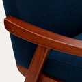 Wood arm close-up | warm espresso wood arm, round fastener, navy upholstery, and angled support