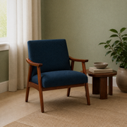 Room one | navy woven armchair in a sage green reading room with warm wood arms and angled legs