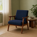 Room one angle | navy woven armchair in the sage green reading room from a second three-quarter view