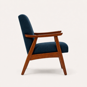 Studio side | navy woven armchair showing the upholstered back, arm rails, open side frame, and rear legs