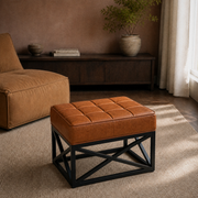 Clay living room | saddle tan leather ottoman with twelve stitched top panels beside a lounge chair