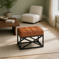 Sage living room | saddle tan leather ottoman with twelve stitched top panels on a plain rug