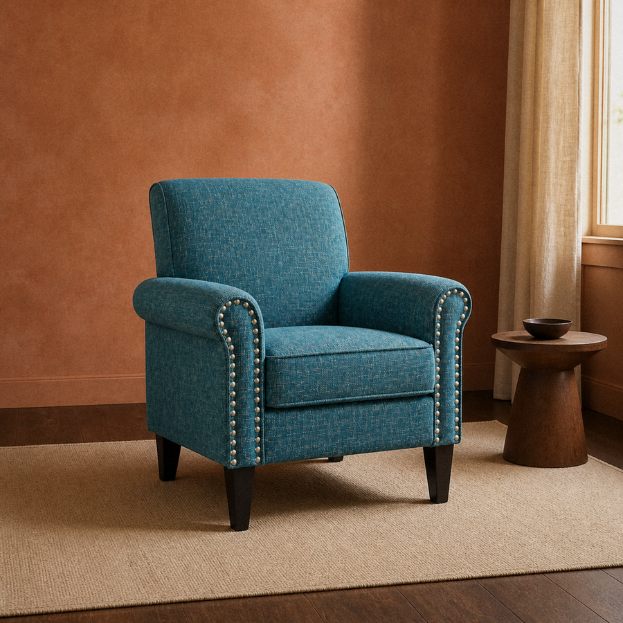 Clay living room | blue-green tweed nailhead armchair on a plain rug beside a walnut pedestal table