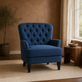 In a room | navy blue tufted accent chair on a cream rug in a terracotta-toned room with a walnut side table
