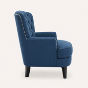 Side | left-side studio view showing the high tufted back, nailhead trim, deep arm, seat cushion, and dark tapered legs