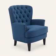 Studio | studio three-quarter view of the dark-blue chair showing its tufted back, nailhead trim, seat cushion, and dark tapered legs