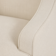 Swoop arm close-up | curved cream upholstered arm and its continuous piping