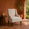 Terracotta room | cream polyester swoop-arm chair on a clay tile floor beneath warm side light