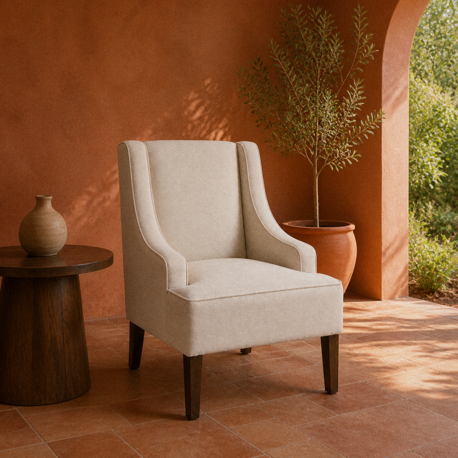 Terracotta room | cream polyester swoop-arm chair on a clay tile floor beneath warm side light