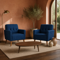 Terracotta room | two deep blue tufted armchairs with a walnut table, olive tree, and arched garden opening in warm afternoon light