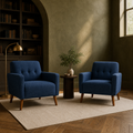 Olive library | two deep blue tufted armchairs on a plain cream rug in an olive plaster library with arch, shelves, and late-day light