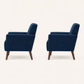 Studio side | paired deep blue armchairs from the right side, showing back slope, flared-arm profile, seat depth, and tapered rear legs