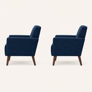 Studio side | paired deep blue armchairs from the right side, showing back slope, flared-arm profile, seat depth, and tapered rear legs