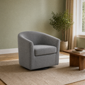 Angle | three-quarter sage green living room view of the slate gray swivel barrel chair with its curved back, side seam, and black swivel base