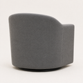 Side | rear-side studio view of the slate gray swivel barrel chair showing the curved rear shell, seams, and low black circular swivel base