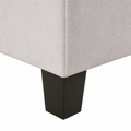 Hardware | close view of a dark solid-wood block foot beneath the ivory upholstery corner and side seam