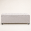 Front | Ivory button-tufted storage bench in clean front elevation on a warm off-white studio ground, with four dark wood block feet