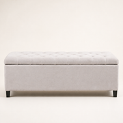 Front | Ivory button-tufted storage bench in clean front elevation on a warm off-white studio ground, with four dark wood block feet