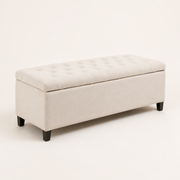 Three-quarter | Ivory button-tufted storage bench from the front-left on a clean studio ground, showing the upholstered end and dark wood feet