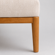 Hardware | close view of the brown rubberwood base rail, tapered leg, and upholstery edge
