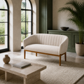 In a room | green millwork room with the beige channel-back loveseat and stone coffee table