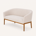 Studio | three-quarter studio view showing the curved channel back, recessed arm, and wood legs