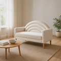 Warm living room angle | Right three-quarter view of the cream textured loveseat with a pale wood coffee table, rug, and window
