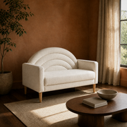 Clay room | Right three-quarter view of the cream textured loveseat in a clay-walled room with a dark wood floor and low oval table